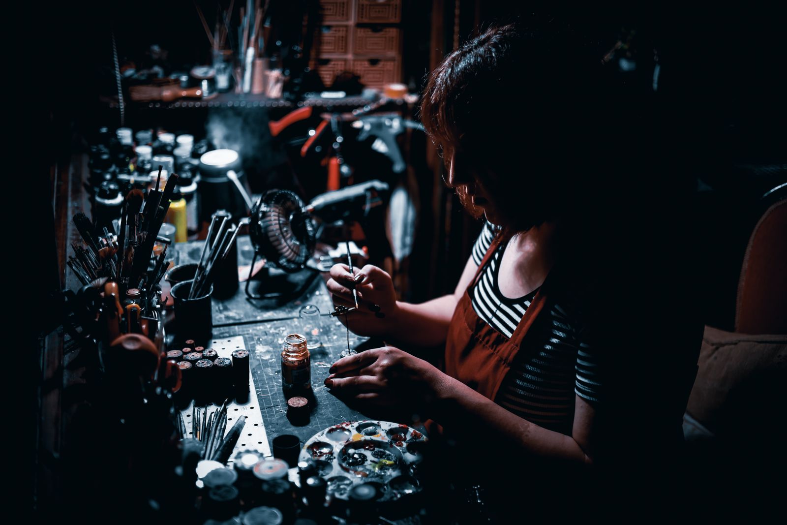 Hobbyist painting a miniature at a workbench