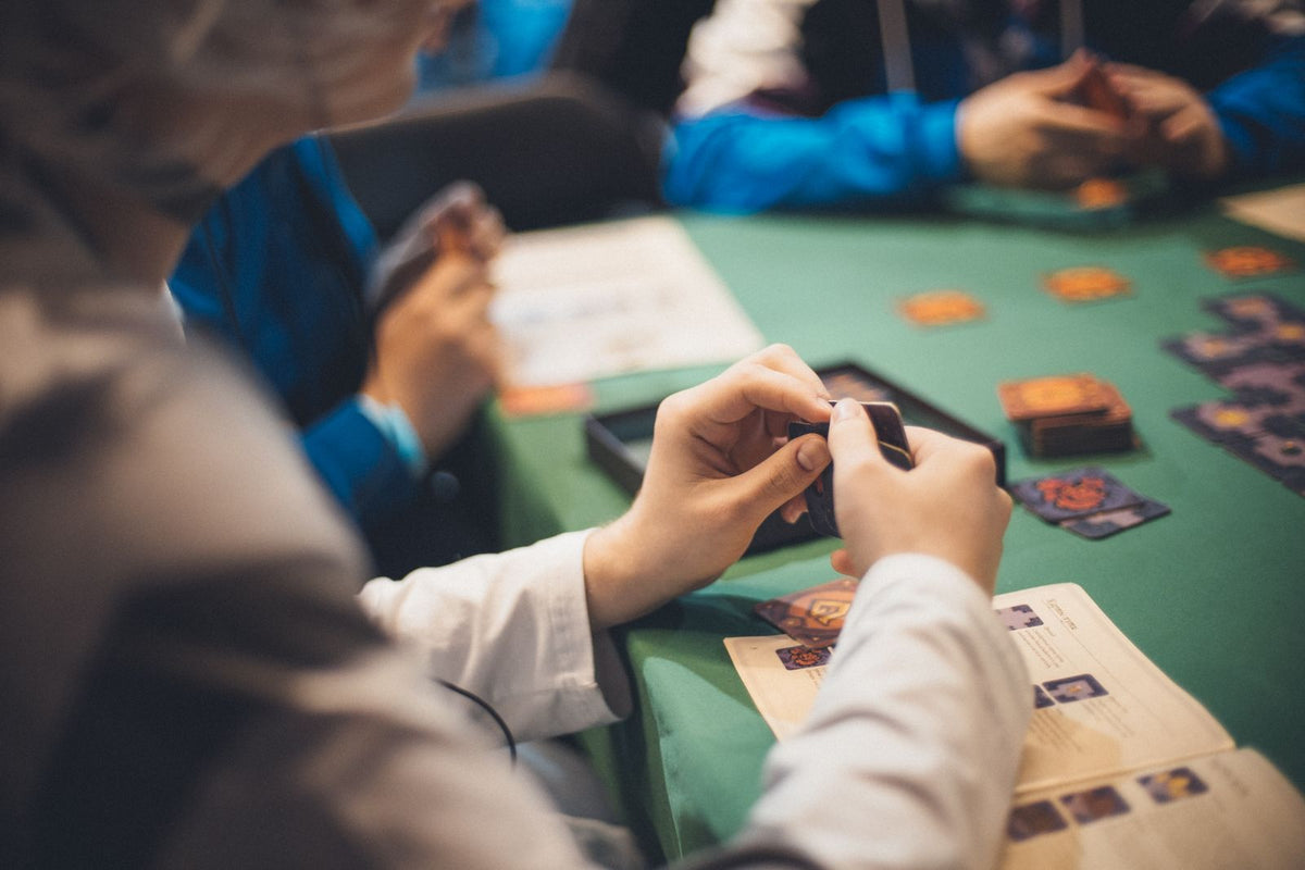 Players handling cards during a tabletop card game